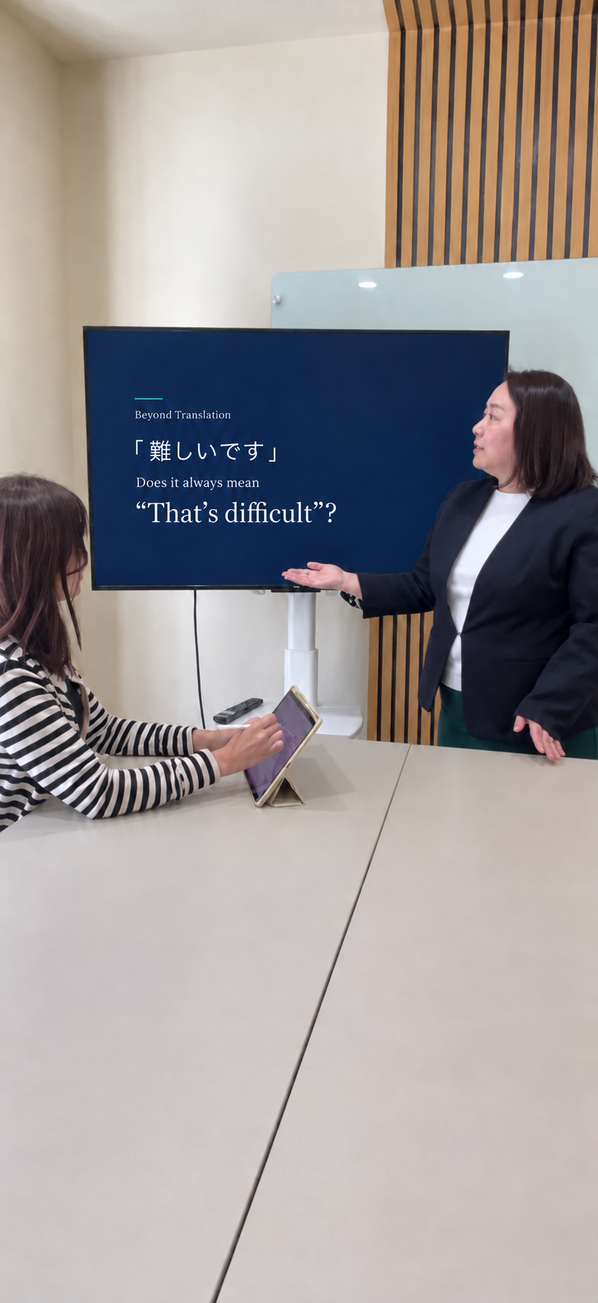 英語のコミュニケーション研修用スライドを説明する講師